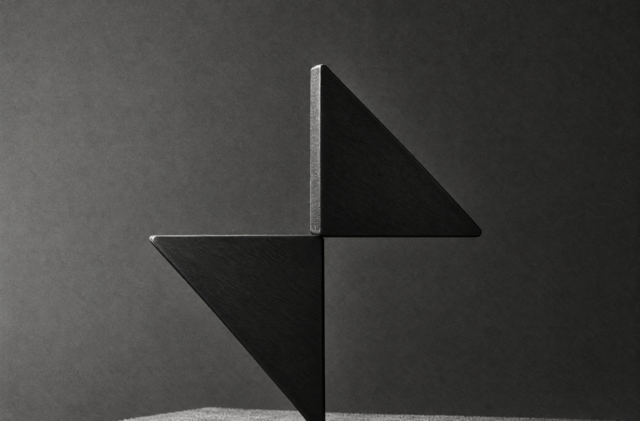 The BarnX mark cut from black steel on a concrete plinth