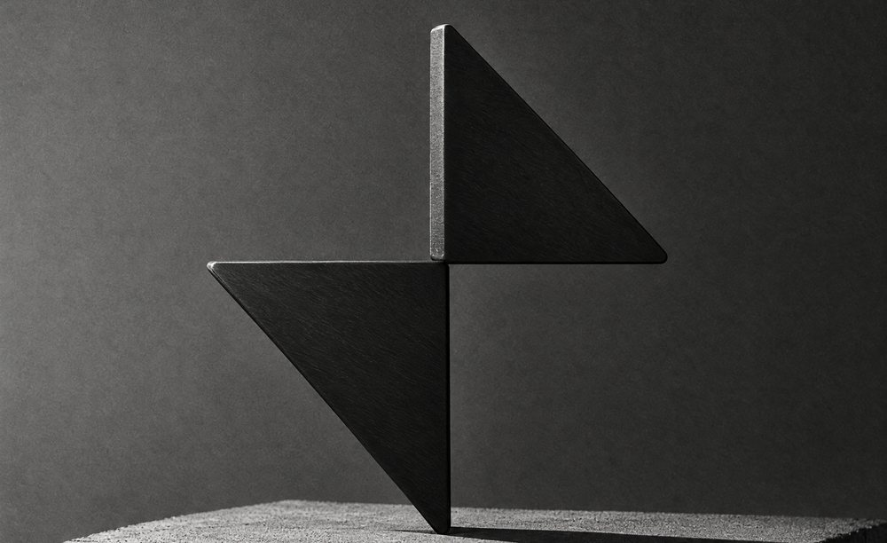 The BarnX mark cut from black steel, standing on a concrete plinth